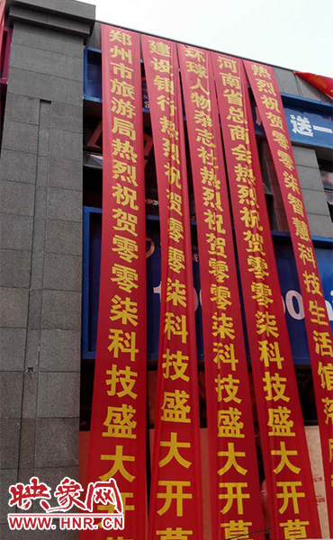 路邊一棟樓上懸掛著二三十條紅色條幅，全部是祝賀一家公司開業(yè)的。