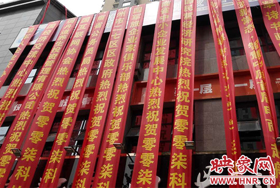 路邊一棟樓上懸掛著二三十條紅色條幅，全部是祝賀一家公司開業(yè)的。