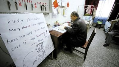 張大爺在門衛(wèi)室里工作，旁邊是紅爆網(wǎng)絡(luò)的溫馨提示牌記者
