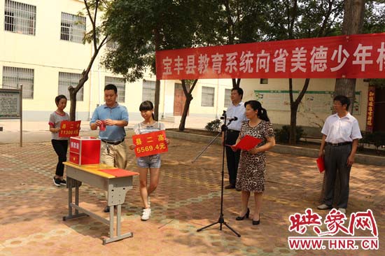 寶豐縣教育系統(tǒng)全體人員在石橋鎮(zhèn)中學(xué)為“美德少年”楊冠明同學(xué)捐款。