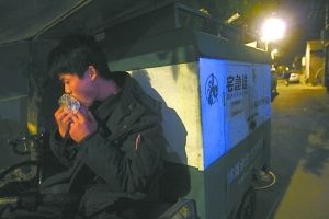 快遞哥抽空吃兩口東西。記者 李剛 攝