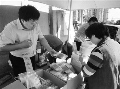 昨日，河南企業(yè)家劉春喜在京“練攤”，為顧客挑選綠豆。新京報記者 張玉學 攝