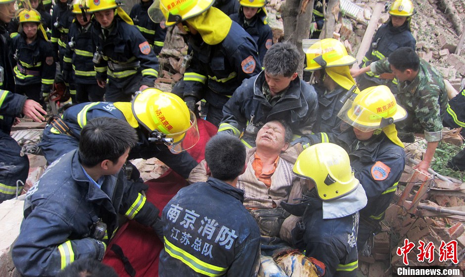 圖為南京消防隊員從廢墟中將傷者抬出。中新社發(fā) 梅亮 攝