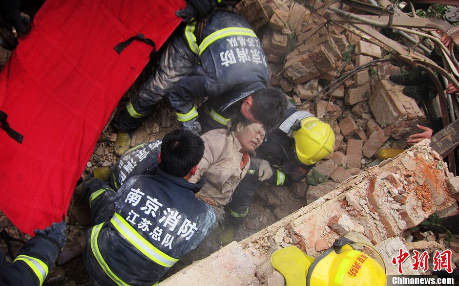 圖為南京消防隊員從廢墟中將傷者抬出。中新社發(fā) 梅亮 攝