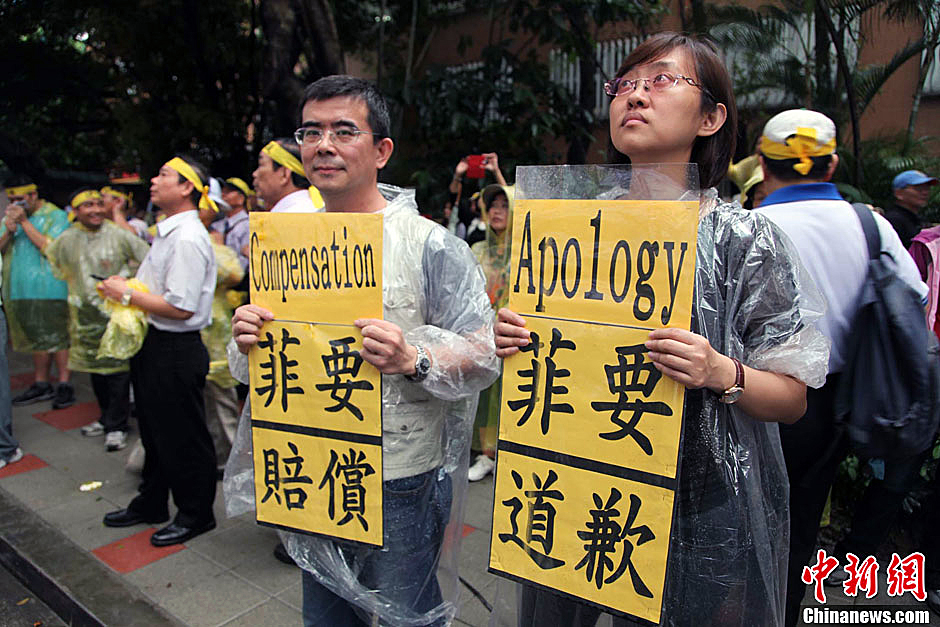 　圖為當(dāng)天下午，當(dāng)臺(tái)灣數(shù)百漁民在馬尼拉經(jīng)濟(jì)文化辦事處前抗議時(shí)，有兩名年輕人手持標(biāo)語，在路邊聲援。中新