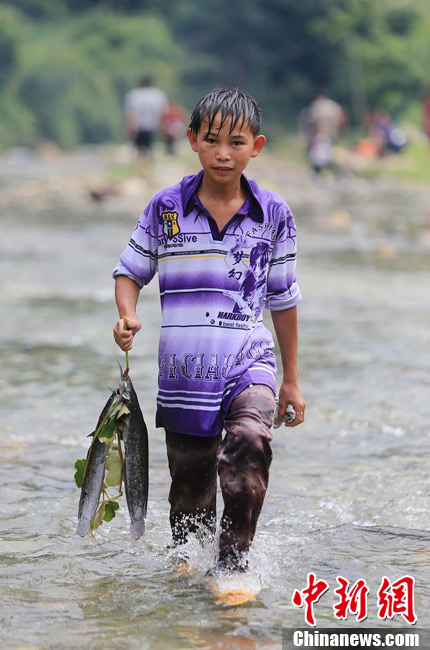 圖為7月9日，一名男孩在鬧魚節(jié)活動(dòng)中抓到了兩條魚。譚凱興 攝
