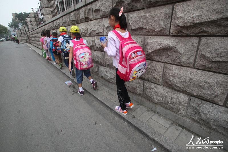 2013年09月11日，濟(jì)南運署街上，小學(xué)生走史上“最窄人行道”上學(xué)。