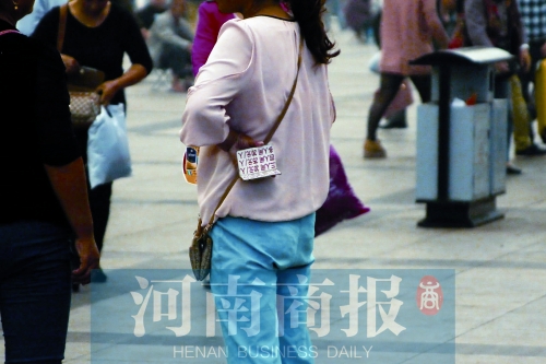 火車(chē)站廣場(chǎng)，一女子拿著寫(xiě)有不同房型價(jià)位的卡片在拉客，不少市民抱怨，受過(guò)此類(lèi)“騷擾”