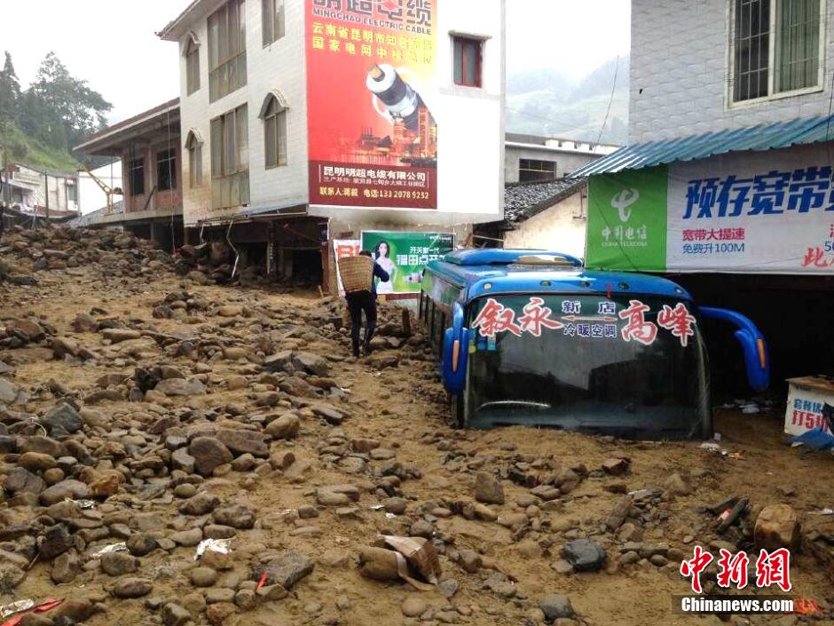 圖為山洪泥石流導沖進鄉(xiāng)鎮(zhèn)街道，導致客車被埋。