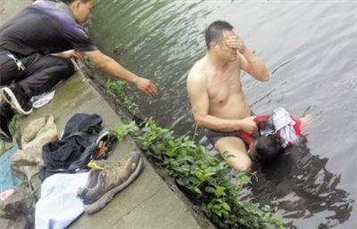 網(wǎng)友貼出民警張光聰一出河水就睜不開眼，用手抹去臉上臟水的照片。