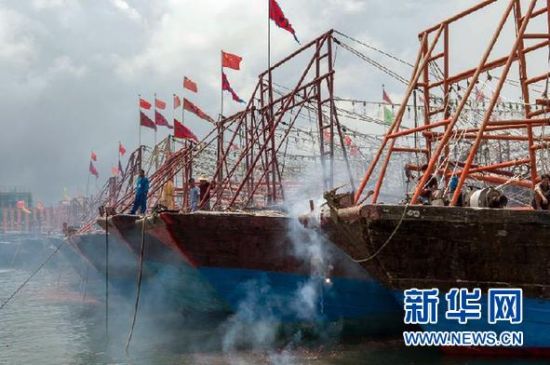 2013年8月1日 南海開漁日 臨高迎新港 8月1日，海南省臨高縣漁民在船上鳴放鞭炮慶祝武蓮港開港。