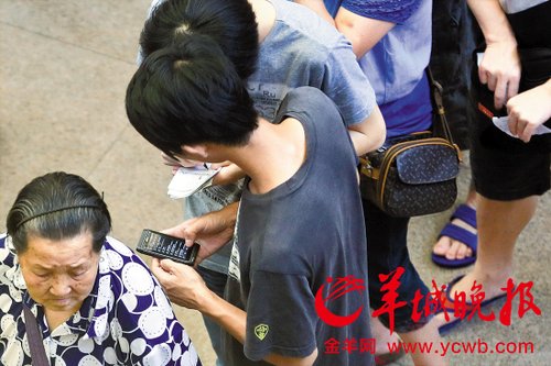排隊的“黃?！备魇謭?zhí)一疊白紙，上面寫好了要掛號的人的信息，包括姓名、電話、要掛的科室等。穿黑白花紋衣服的老婆婆正在排隊掛號