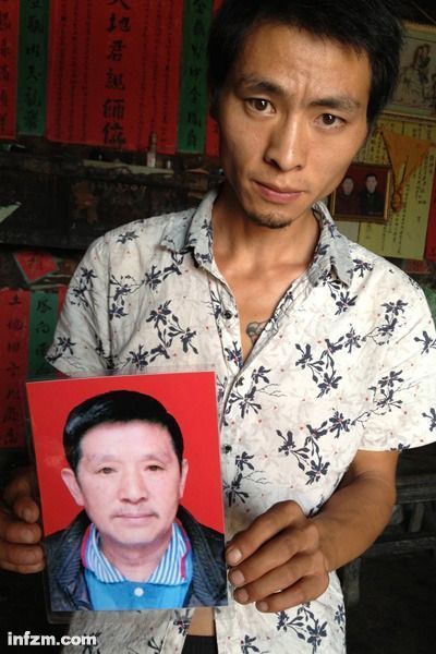 程興貴的兒子程正鵬拿著父親的遺照。程興貴自殺后，政府補償程家6000多塊錢，并終于認定了程興貴的代課教齡。 (南方周末記者雷磊/圖)