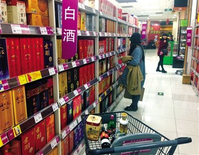 顧客在商場的高檔白酒貨架前駐足挑選。春節(jié)臨近，受“禁令”影響，以高檔白酒為代表的節(jié)日禮品市場面臨考驗。記者 王遠征 攝