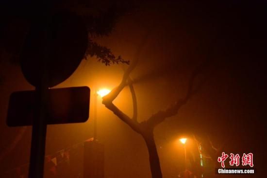 1月31日凌晨，市民行走在煙霧繚繞的南京街頭。當(dāng)天是農(nóng)歷馬年正月初一，南京有限開(kāi)禁燃放煙花爆竹正逢下霧天，空氣的不流通致使煙花爆竹燃燒后產(chǎn)生的顆粒物不能及時(shí)散開(kāi)，造成整座城市煙霧繚繞。據(jù)當(dāng)?shù)丨h(huán)保部門(mén)發(fā)布的信息顯示，空氣質(zhì)量屬重度污染。中新社發(fā) 泱波 攝