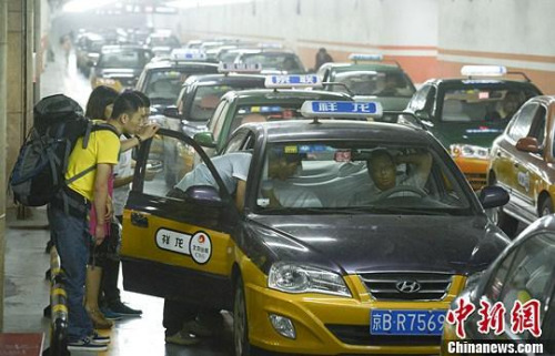 市民在北京西客站出租車候車點準備乘車。中新社發(fā) 侯宇 攝