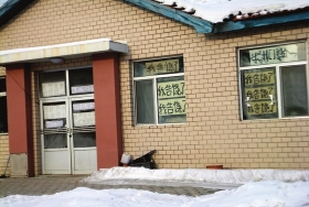 伊春市帶嶺區(qū)一排破舊的平房，房間窗戶上貼滿了“我告饒了”的字樣。