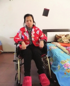 陳慶霞坐在輪椅上。她現(xiàn)在下身癱瘓，疾病纏身，生活不能自理。