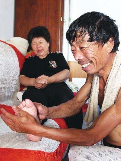 慈成富為老伴按摩。