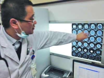 醫(yī)生在查看男孩的腦部CT片。薛馬義 攝