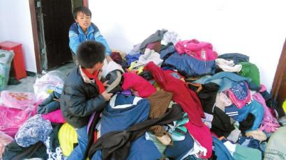 學生在幫忙整理收到的捐贈衣服。得石中心校供圖