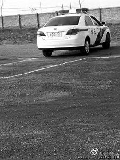 一輛車(chē)牌號(hào) 為“ 陜DD173”的制式警車(chē)停在一個(gè)劃著白線的場(chǎng)地上，車(chē)身標(biāo)有“司法”字樣