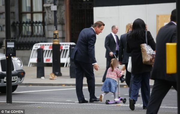 英國(guó)首相卡梅倫步行送女兒上幼兒園。