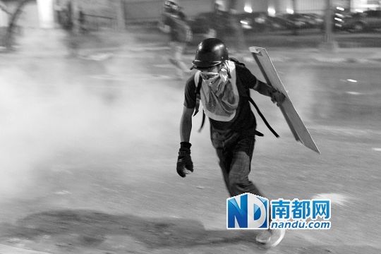 反政府示威者在與警察的沖突中躲避催淚彈。