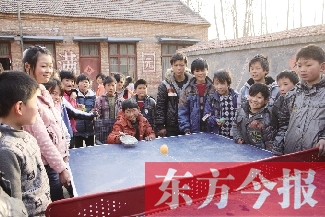 坐著輪椅的小宗成和同學(xué)們一塊打乒乓球，這是他感到最快樂(lè)的事