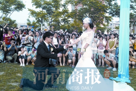 在學(xué)校操場(chǎng)的草坪上，兩名畢業(yè)生舉行婚禮，有同學(xué)感動(dòng)地抹起眼淚
