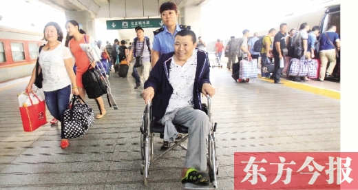 李剛手術(shù)后歸來，在車站工作人員幫助下走出鄭州火車站站臺(tái)  東方今報(bào)首席記者 張曉冬 攝
