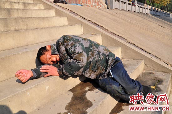 這名男子的衣服以及褲子全濕透了，水從衣褲里流出來，嘴里散發(fā)著濃烈的酒氣。