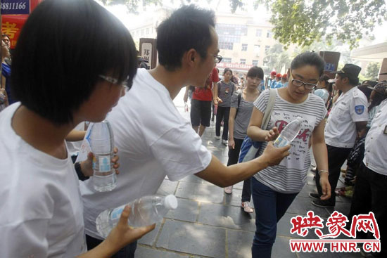 志愿者為剛剛考試完的考生送上1瓶冰凍的冰露·純悅，消暑解渴為考生加油