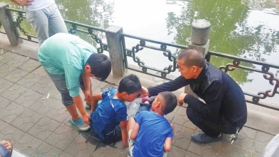 男孩被救出后，圍觀群眾幫他控水換衣服。