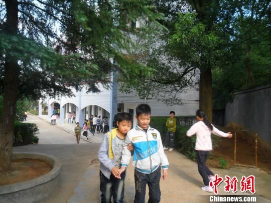 4年來，13歲的余興泉（左一）每天都攙扶著腿腳不便的同學(xué)左臣進出教室、食堂和廁所。 李俊杰 攝