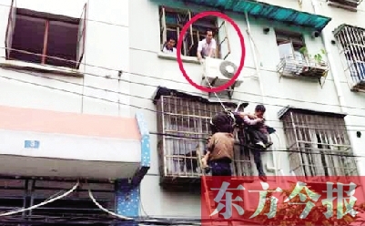 施救現(xiàn)場(chǎng)，劉鵬（圈內(nèi)）先用繩子捆住老太確保安全 勞動(dòng)報(bào)記者 郭娜 供圖