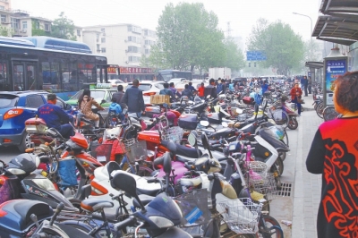 省人民醫(yī)院北門，路邊的公交站牌處停滿非機動車，上、下客只能在快車道上。