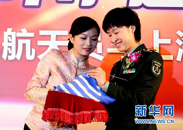 11月1日，航天員劉洋（右）在為“愛心”毛衣編織最后的收尾針。