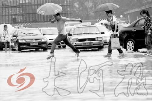 鄭州經(jīng)三路與北環(huán)交叉口處，積水較深，行人們不得不“練輕功”。 記者 白周峰 攝影