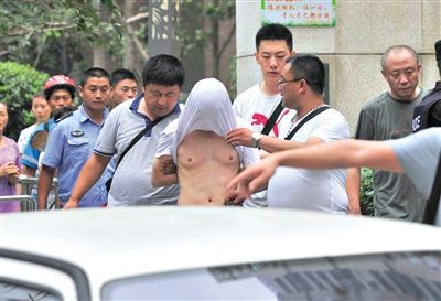 昨日，成都警方抓捕時(shí)與毒犯發(fā)生槍戰(zhàn)。一名男犯罪嫌疑人被警方押出。
