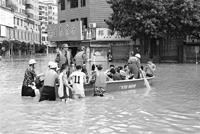 18日，廣東省清遠市陽山縣縣城,消防官兵合力推動沖鋒舟，轉(zhuǎn)移被困學生。新華社發(fā)