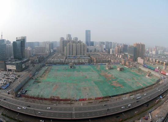 2016年4月，經(jīng)過持續(xù)攻堅，親賢社區(qū)西北片區(qū)的拆遷工作基本告一段落，但在鋪設(shè)了防塵綠網(wǎng)的空地中，至今仍有3戶居民選擇了“堅守”。(拍攝：2016年4月4日)