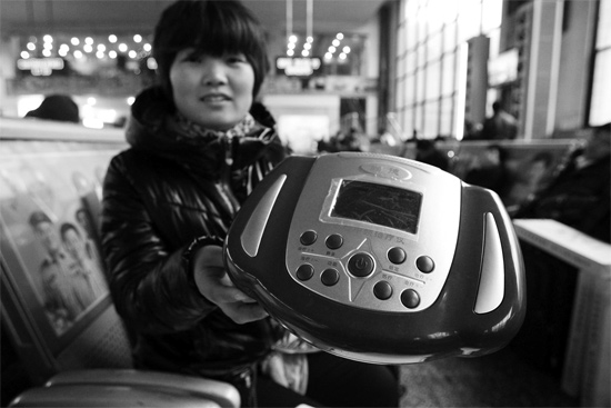 火車站候車室，李女士向記者展示她準(zhǔn)備孝敬父母的按摩儀