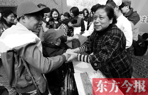 昨日，鄭大四附院的大樓前，“面人鄭”鄭玉芬（右）向前來(lái)捐款的殘疾人表示感謝