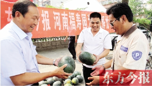 河南福壽園區(qū)域總經(jīng)理吳正宗（左一）、東方今報(bào)發(fā)行中心副總監(jiān)王路喜（中）在街頭給市民送瓜