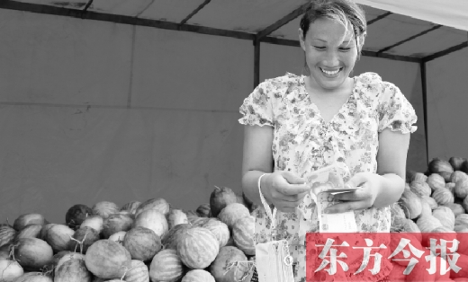 昨日，開(kāi)封瓜農(nóng)史瑩瑩幸福地?cái)?shù)著賣(mài)瓜錢(qián) 東方今報(bào)記者 沈翔 攝