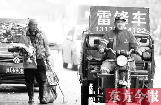 鄭州市商城路，一名環(huán)衛(wèi)工懷抱著剛剛收到的毯子，目送“雷鋒哥”孫德坤離開