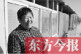 在京水村的臨時過渡區(qū)內(nèi)，一位大媽在儲存大白菜