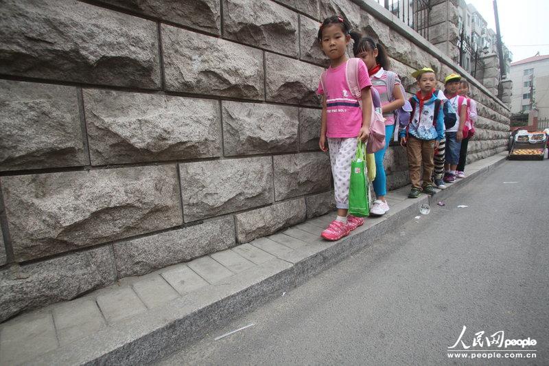 2013年09月11日，濟(jì)南運署街上，小學(xué)生走史上“最窄人行道”上學(xué)。圖片來源：CFP