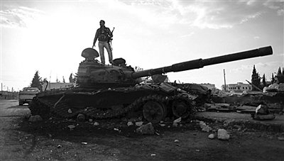 9月8日，敘利亞Zabadani，一名敘利亞反對派武裝人員站在廢棄的政府軍坦克上。